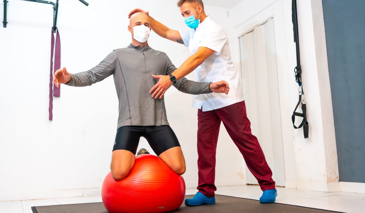 client balancing on a red ball assisted by physiot 2024 12 09 04 29 54 utc scaled